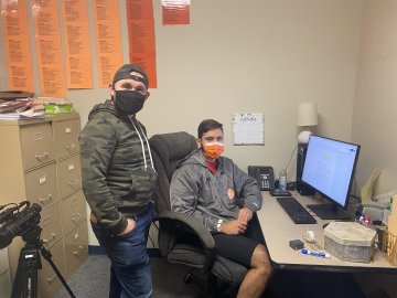 Students wearing masks work at computer on a new edition of The Tangerine newsaper.