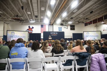 Students and families in rows of chairs, are greeted by members of the Utica community at a November 2025 Open House event.