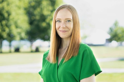 Hannah Barley in green shirt, outside, smiling.