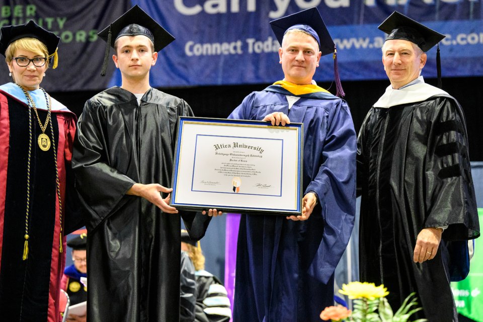 President Laura Casamento, Vasyl Yurkuts, Professor Maxim Gorbachevsky, and Chair of Utica University Board of Trustees Robert Brvenik accept honorary degree on behalf of Ukrainian President Volodymyr Zelenskyy.